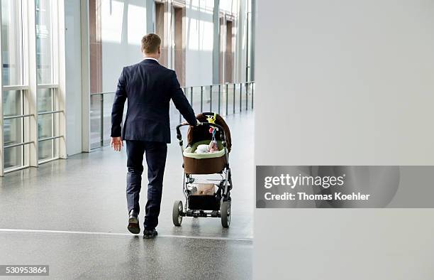 Young business man pushes a stroller on Mai 02, 2016 in Frankfurt, Germany.