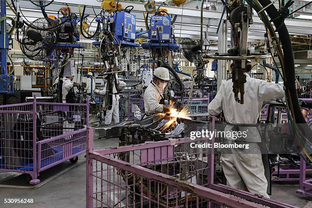Employees weld parts of Honda Civic vehicles as they work on the production line of the Honda Motor Co. Assembly plant in Prachinburi, Thailand, on...