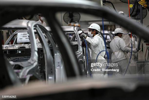 Employees weld parts of Honda Civic vehicles as they work on the production line of the Honda Motor Co. Assembly plant in Prachinburi, Thailand, on...