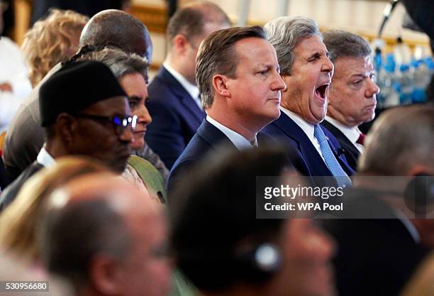 British Prime Minister David Cameron sits beside U.S. Secretary of State John Kerry as they listen during a panel discussion at the international...