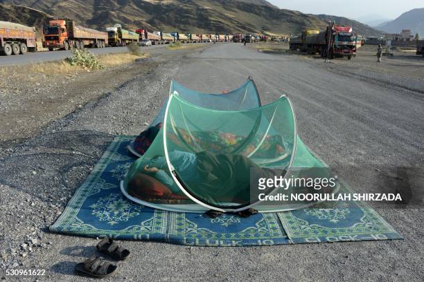 Afghan civilians sleep along a road near the Torkham border between Afghanistan and Pakistan in Nangarhar province on May 12, 2016. - Torkham, the...