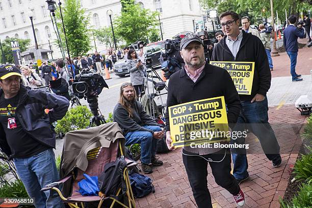 Protesters and members of the media gather outside of the Republican National Committee headquarters during a meeting inside with presumptive...