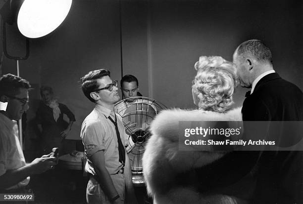 Marilyn Monroe stands wearing a white fur stole wrap with director Billy Wilder for a publicity shoot with Richard Avedon in his studio during the...