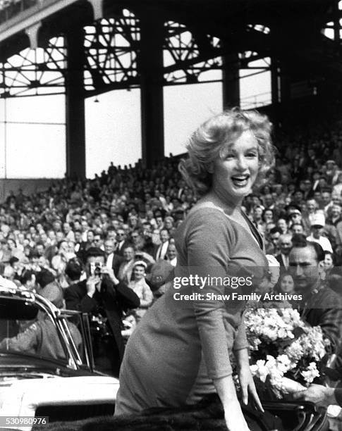 Marilyn Monroe rides in a convertible car at the ceremonial kick off for a match between a combined Israeli Hapoel team and the American Soccer...