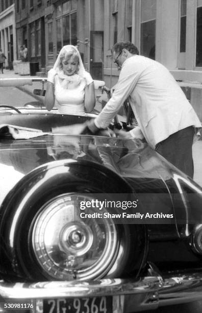 Marilyn Monroe with her husband, the playwright Arthur Miller, preparing to get into a convertible Ford Thunderbird in 1957 in New York, New York.