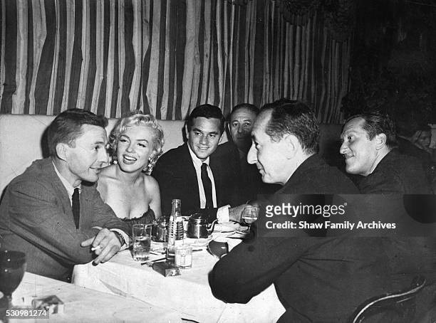 Marilyn Monroe with actor David Wayne, photographer Milton Greene, newspaper columnist Leonard Lyons, and playwright Sidney Kingsley at the 'Little...