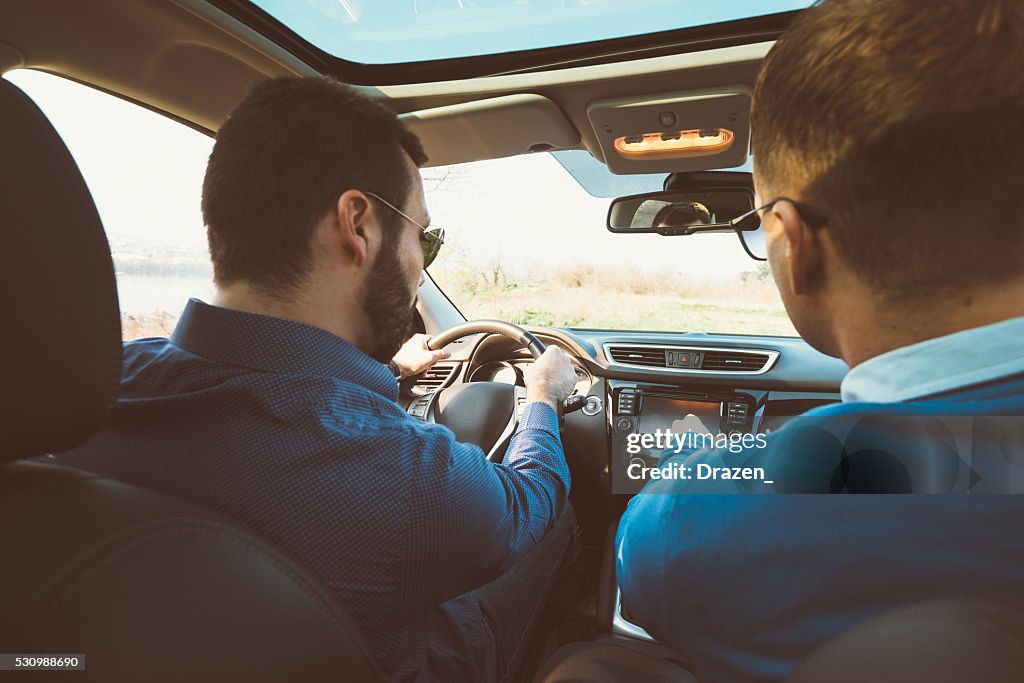 Porträt von zwei gut aussehender Mann in Auto fahren für den Urlaub