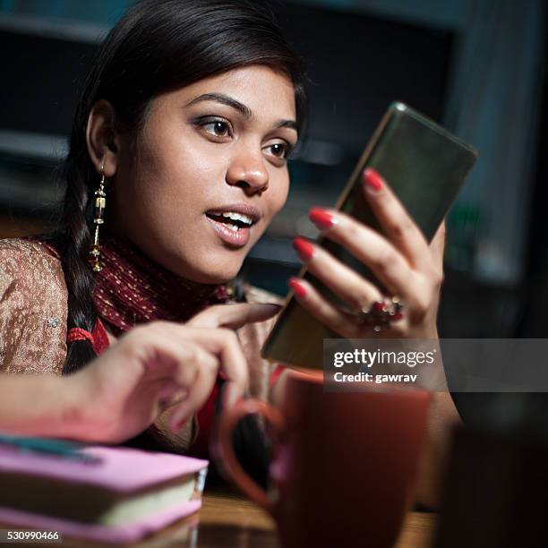 girl on study table with books coffee mug using smartphone. - coffee table reading mug stock pictures, royalty-free photos & images