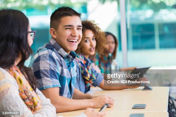 high school or college student laughing with classmates at desk - beautiful college girls stock pictures, royalty-free photos & images
