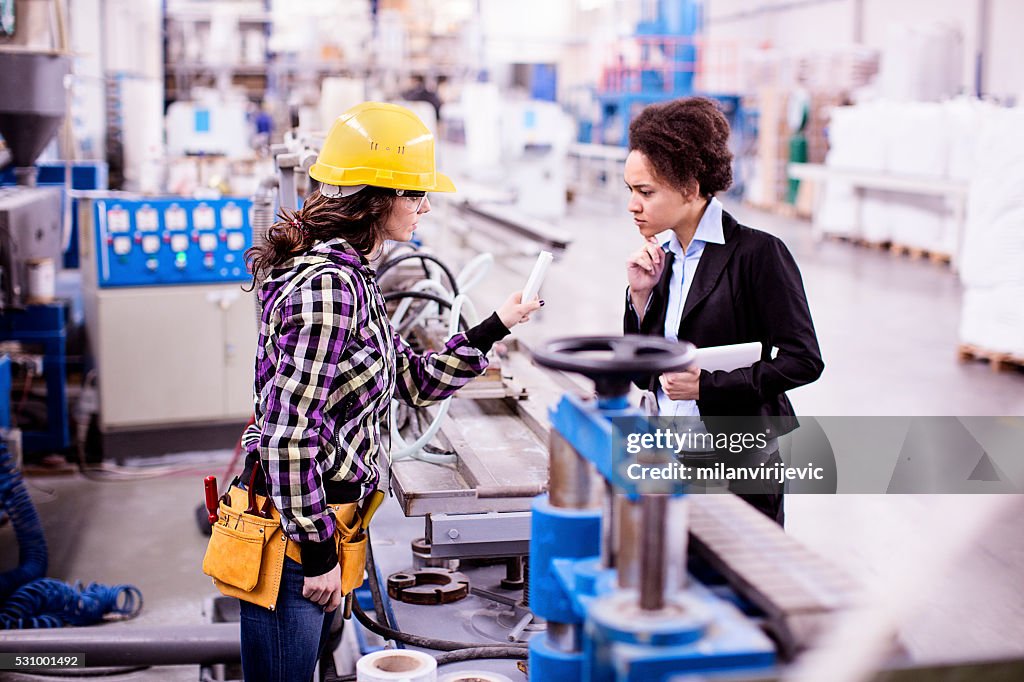 Girl in a factory working with her woman boss