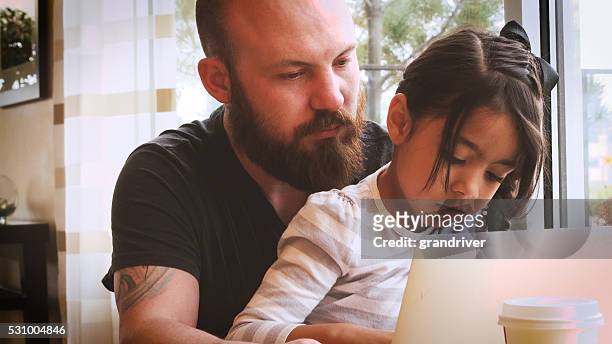 young caucasian man helping little hispanic girl with laptop - bald girl stock pictures, royalty-free photos & images