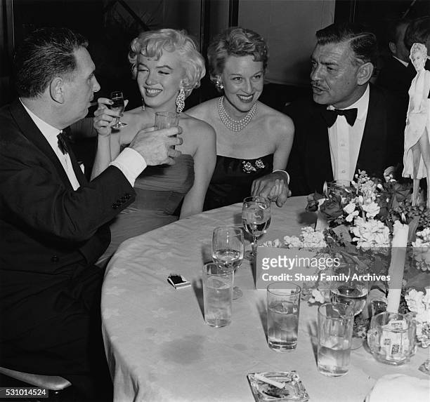 Marilyn Monroe with actor Clark Gable, producer Charles K Feldman and actress Jean Howard at the wrap party for the filming of "The Seven Year Itch"...