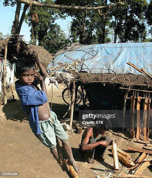 Indian child Kanu Baske of the Adibashi Santhal tribe plays near his temporary shelter at a refugee camp located in the Bodo Territorial Council And...