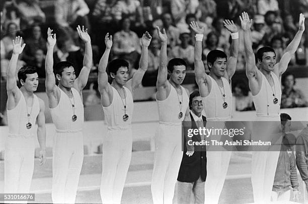 Gold medalists Hiroshi Kajiyama, Eizo Kenmotsu, Hisato Igarashi, Sawao Kato, Shun Fujimoto and Mitsuo Tsukahara of Japan celebrate on the podium at...