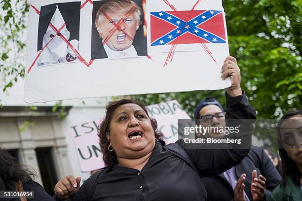 Demonstrator holds a sign against Donald Trump, presumptive Republican presidential nominee, during a meeting with U.S. House Speaker Paul Ryan,...