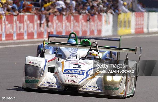Danish Tom Kristensen leads the last lap with his Audi-Champion R8 number 3, during the 73rd edition of Le Mans 24 Hours car race followed by...