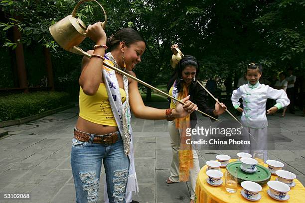 Contestants of 2005 Miss Tourism Queen International, Miss Jamaica and Miss Sri Lanka learn to pour tea with traditional long-mouth tea pots from a...