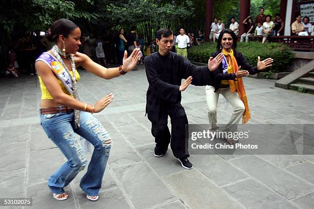 Contestants of 2005 Miss Tourism Queen International, Miss Jamaica and Miss Sri Lanka learn Chinese kung fu from a coach at a park during a...