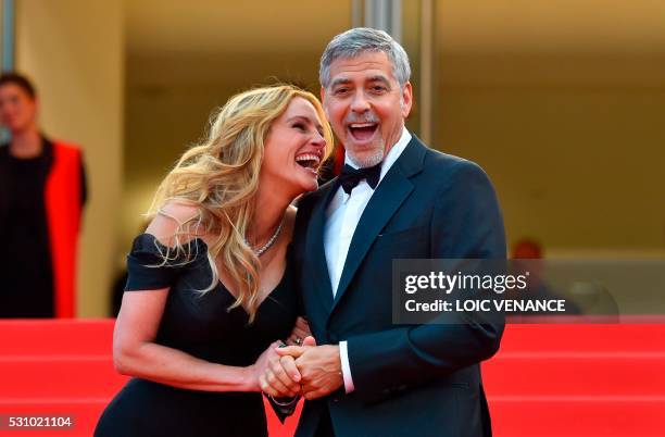 Actress Julia Roberts laughs on May 12, 2016 with US actor George Clooney as they arrive for the screening of the film "Money Monster" at the 69th...