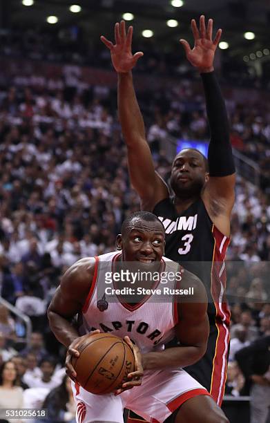 Bismack Biyombo looks for a way around Dwyane Wade as the Toronto Raptors beat the Miami Heat in game five 99-91 of their Eastern Conference...