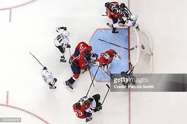 Mike Richards of the Washington Capitals and Evgeni Malkin of the Pittsburgh Penguins are broken up by linesman Jonny Murray during the first period...