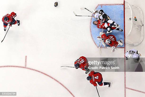 Nate Schmidt of the Washington Capitals is checked by Carl Hagelin of the Pittsburgh Penguins behind goalie Braden Holtby during the third period in...