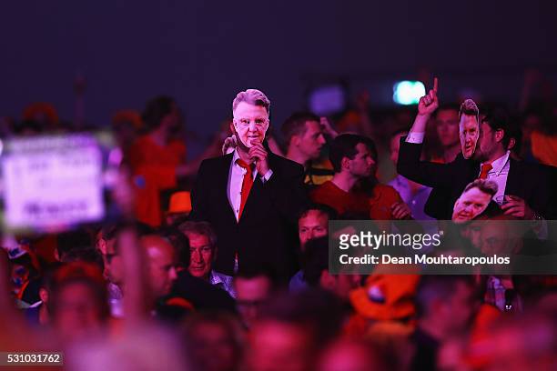 Fans with Louis van Gaal masks cheer as Robert Thornton of Scotland plays against James Wade of England during the Darts Betway Premier League Night...