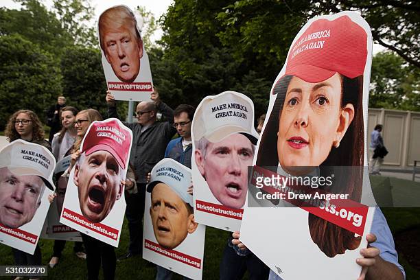 Protestors, hold photos of Republican Senators, rally outside of the the National Republican Senatorial Committee office, where Donald Trump is...