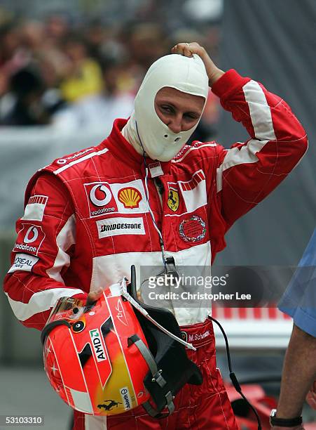Michael Schumacher of Germany and Ferrari takes his balaclava off after he wins the United States F1 Grand Prix at the Indianapolis Motor Speedway on...