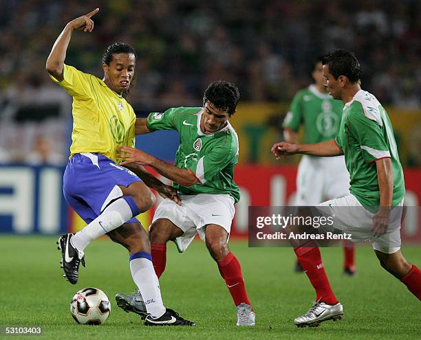 Ronaldinho of Brazil challenges with Zinha and Mario Mendez of Mexico during the FIFA Confederations Cup 2005 match between Mexico and Brazil on June...