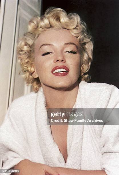 Marilyn Monroe leans out of a window wearing a bathrobe in 1954 during the filming of "The Seven Year Itch" in New York, New York.