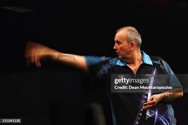 Phil 'The Power' Taylor of England plays a shot in his match against Michael van Gerwen of the Netherlands during the Darts Betway Premier League...