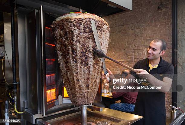 türkische cook skulptur fleisch von großer vertikaler spit - gyros stock-fotos und bilder