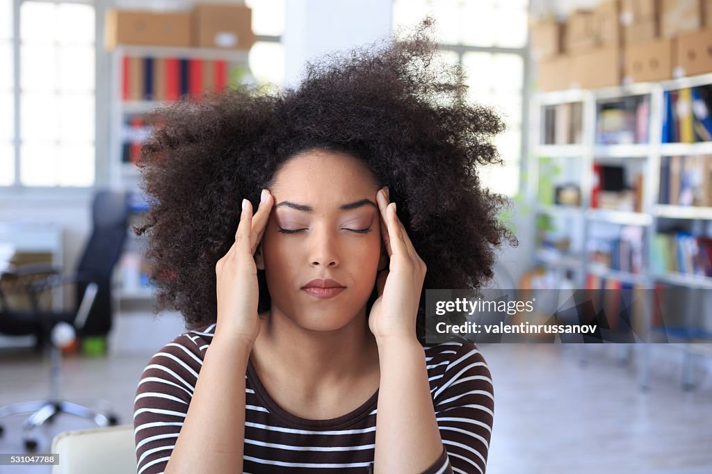 Young woman with headache at the office