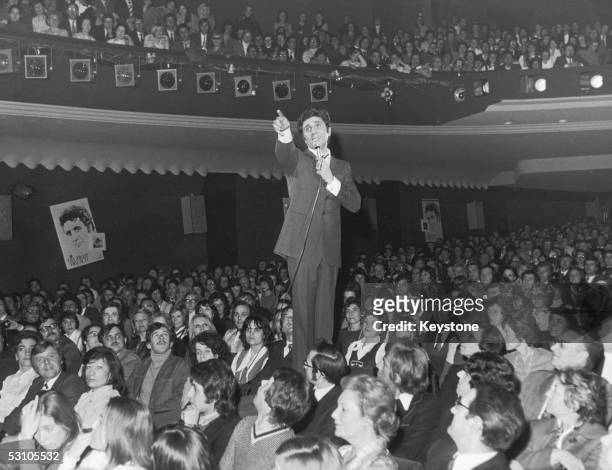 French singer and songwriter Gilbert Becaud among the audience at the Olympia Theatre, Paris, 20th March 1973, during a concert to celebrate his...