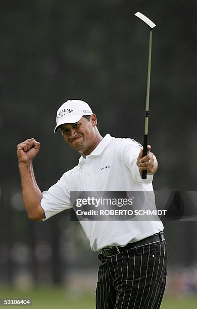 Pinehurst, UNITED STATES: Michael Campbell of New Zealand raises his putter as he pumps his fist after sinking a birdie putt on the 12th green at the...