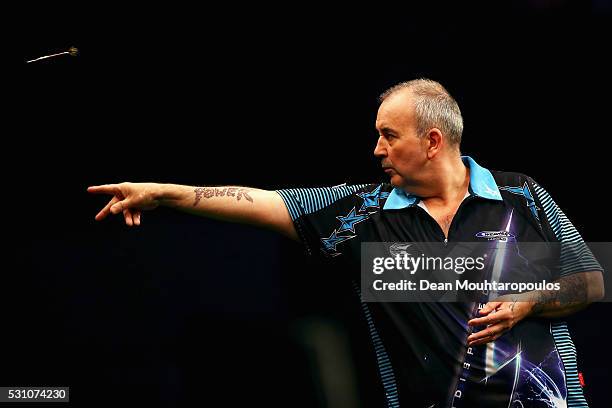 Phil 'The Power' Taylor of England plays a shot in his match against Michael van Gerwen of the Netherlands during the Darts Betway Premier League...