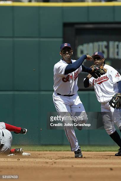 Alex Cora of the Cleveland Indians fields as Ronnie Belliard looks on during the game against the Los Angeles Angels of Anaheim at Jacobs Field on...