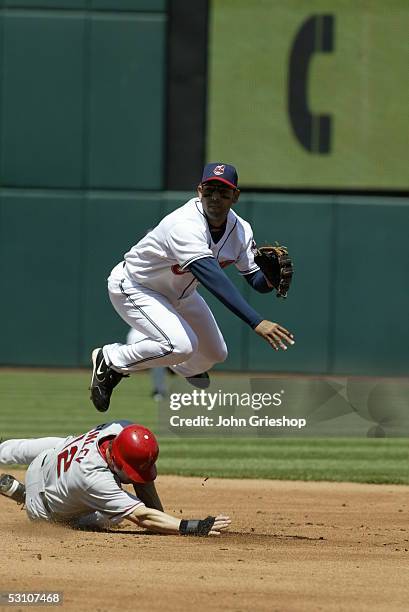 Alex Cora of the Cleveland Indians leaps and throws as Anaheim's Steve Finley slides during the game against the Los Angeles Angels of Anaheim at...