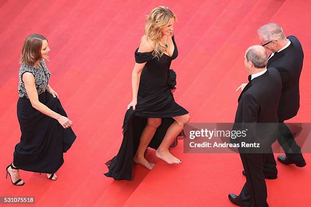 Producer Jodie Foster and actress Julia Roberts, walking bare foot, walk up upon their arrival at the 'Money Monster' premiere during the 69th annual...