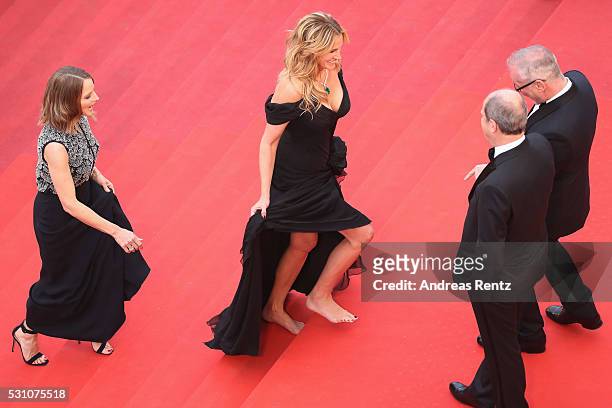 Producer Jodie Foster and actress Julia Roberts, walking bare foot, walk up upon their arrival at the 'Money Monster' premiere during the 69th annual...