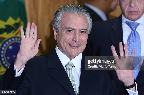Brazil's interim President Michel Temer waves at a signing ceremony for new government ministers at the Planalto presidential palace after the Senate...