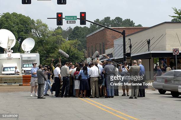 Reporters gather in the middle of the street to speak with defense attorney James McIntyre outside the Neshoba County Courthouse while the jury...