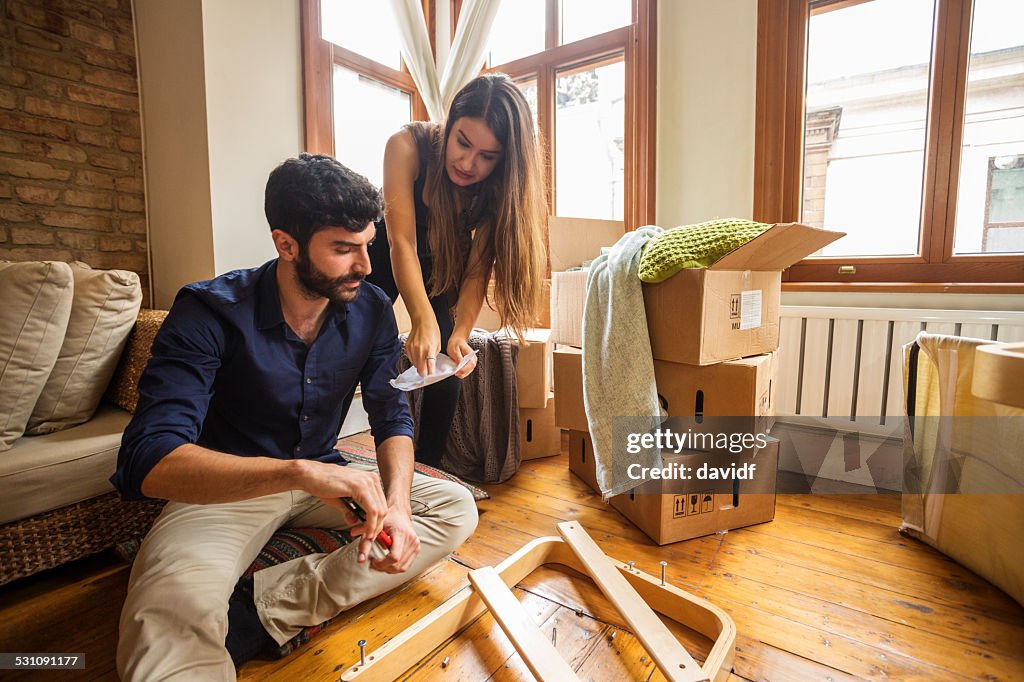 Couple Having Fun Moving In and Assembling Furniture