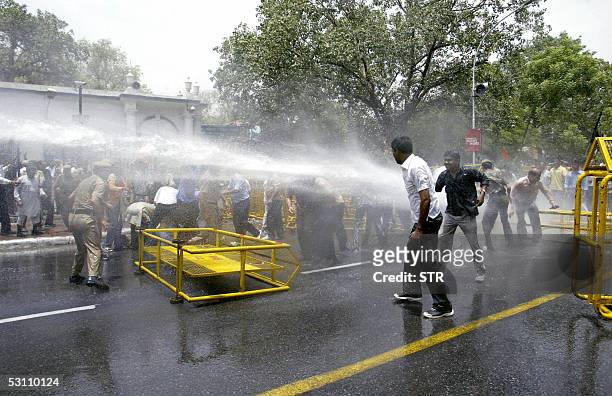 Indian policemen use water cannon to disperse workers from the Bharatiya Janata Party as they hold a demonstration against fuel price rises announced...