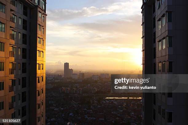 sunset from the apartment - jakarta slum stock pictures, royalty-free photos & images