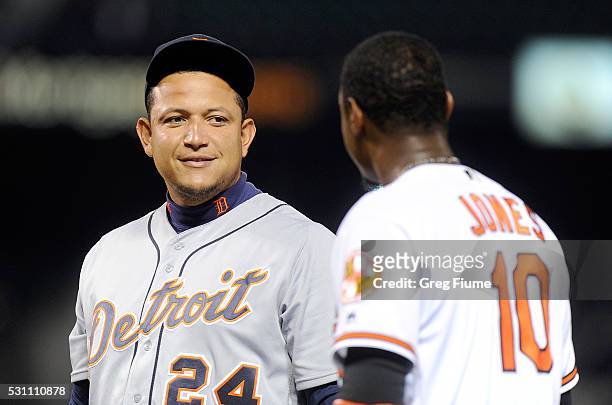 Miguel Cabrera of the Detroit Tigers talks with Adam Jones of the Baltimore Orioles during a pitching change in the seventh inning at Oriole Park at...