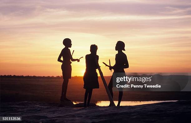 Aboriginal boys Rowen, Brian and Thomas making music as the sun goes down near Wulk, western Arnhem Land