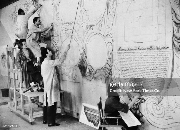 American artist Allen Saalburg directs WPA artists at work in a temporary studio at the American Museum of Natural History on murals commissioned for...