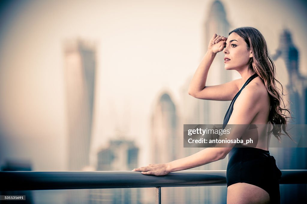 Woman in swimming pool watches cityscape